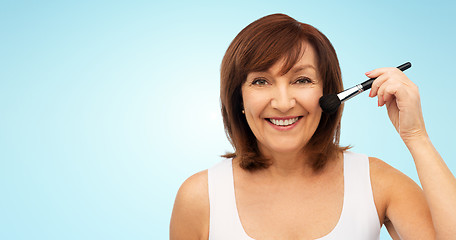 Image showing smiling senior woman with make up blush brush