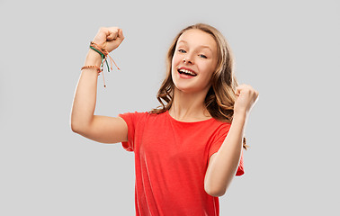 Image showing happy teenage girl in red celebrating triumph