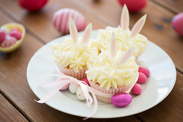 Image showing cupcakes with easter eggs and candies on table