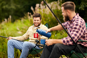 Image showing friends fishing and drinking tea from thermos