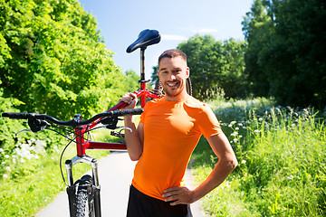 Image showing happy young man with bicycle outdoors in summer