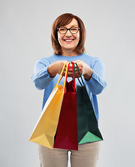 Image showing senior woman with shopping bags over grey