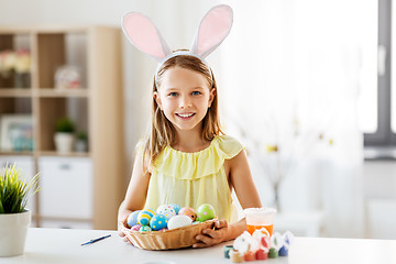 Image showing happy girl with colored easter eggs at home