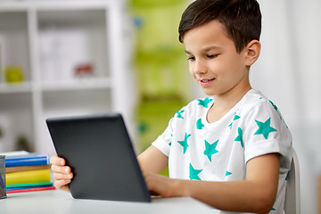 Image showing student boy with tablet pc and notebook at home