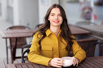 Image showing teenage girl drinking hot chocolate at city cafe