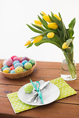 Image showing easter eggs in basket, plates, cutlery and flowers