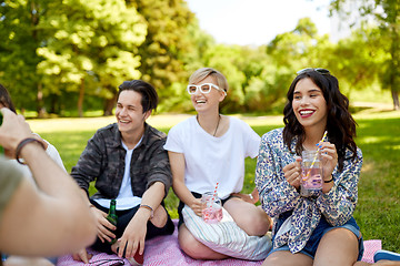 Image showing happy friends with drinks at picnic in summer park