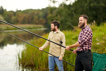 Image showing friends with fishing rods at lake or river