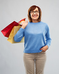 Image showing senior woman with shopping bags over grey