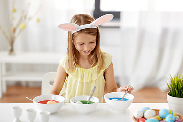 Image showing girl coloring easter eggs by liquid dye at home