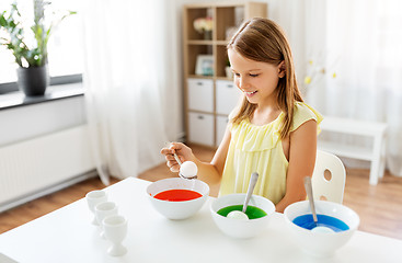 Image showing girl coloring easter eggs by liquid dye at home