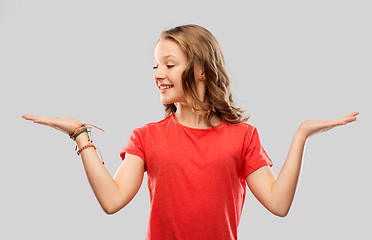 Image showing smiling teenage girl holding empty hand