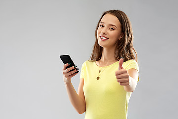 Image showing teenage girl with smartphone showing thumbs up