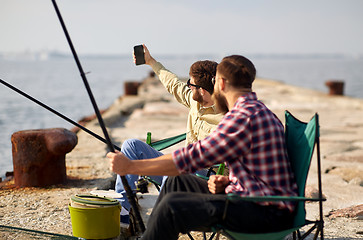 Image showing friends fishing and taking selfie by smartphone