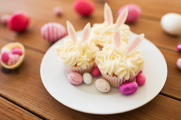 Image showing cupcakes with easter eggs and candies on table