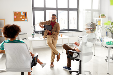 Image showing man showing tablet pc to creative team at office