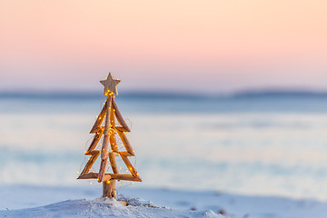 Image showing Christmas tree with fairy lights on the beach in summer