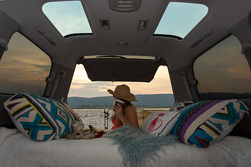 Image showing Woman on road trip with her van has a rest break