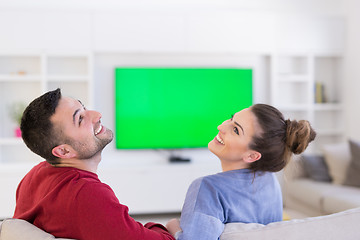 Image showing Young couple on the sofa watching television