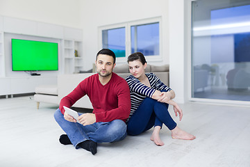 Image showing Young Couple using digital tablet on the floor