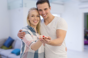 Image showing couple showing small red house in hands