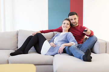 Image showing Young couple on the sofa watching television