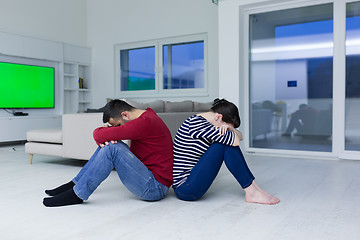 Image showing young couple sitting with back to each other on floor