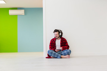 Image showing young man enjoying music through headphones