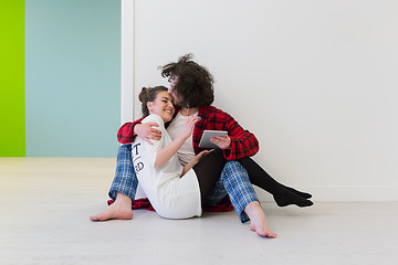 Image showing Young Couple using digital tablet on the floor