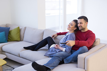 Image showing Young couple on the sofa watching television