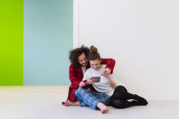 Image showing Young Couple using digital tablet on the floor