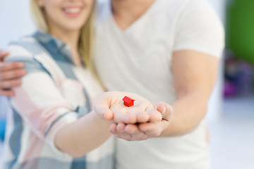 Image showing couple showing small red house in hands