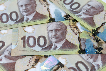 Image showing 100 Canadian dollar banknotes.