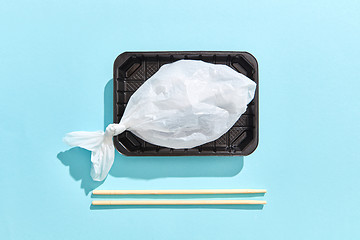 Image showing Dinner container with fish from plastic bag served wooden chopsticks.