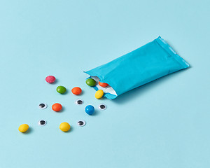 Image showing Paper box with colorful candy and pupils on a light blue background.