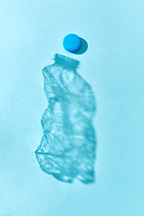 Image showing Shadow from crushed plastic bottle with blue top.