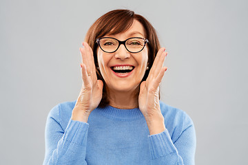 Image showing senior woman in glasses calling over grey