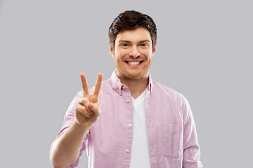 Image showing young man showing two fingers or peace hand sign