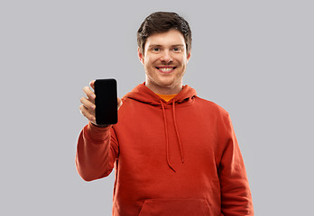 Image showing smiling man in red hoodie showing black smartphone