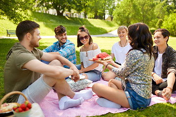 Image showing happy friends eating watermelon at summer picnic