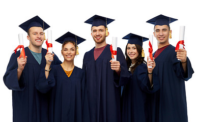 Image showing graduates in mortar boards with diplomas