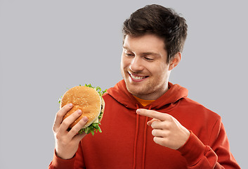 Image showing happy young man showing hamburger