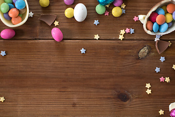 Image showing chocolate eggs and candy drops on wooden table