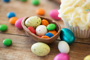 Image showing close up of chocolate egg with candies and cupcake