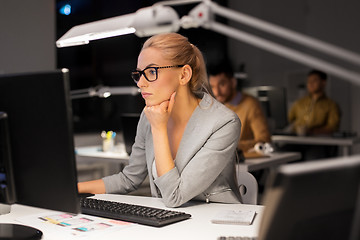 Image showing businesswoman working at computer in night office