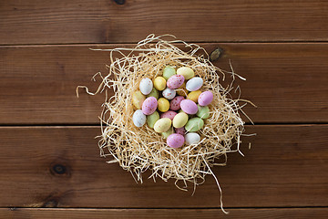 Image showing easter eggs in straw nest on wooden table