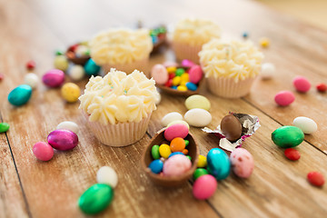 Image showing cupcakes with chocolate eggs and candies on table