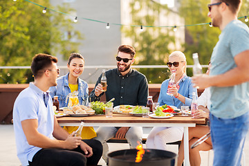 Image showing happy friends having bbq party on rooftop