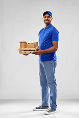 Image showing happy indian delivery man with food and drinks