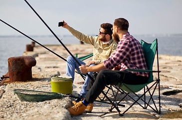 Image showing friends fishing and taking selfie by smartphone